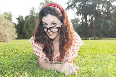 girl with big glasses and strange expressions at the parkの写真素材