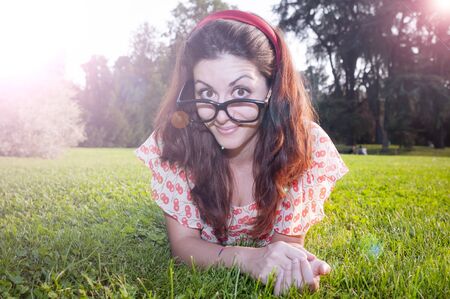 girl with big glasses and strange expressions at the parkの写真素材
