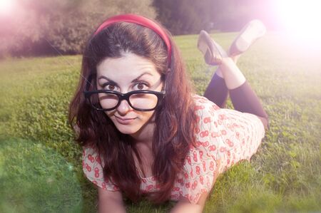 girl with big glasses and strange expressions at the parkの写真素材