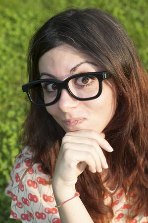 girl with big glasses and strange expressions at the parkの写真素材