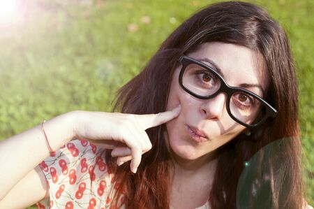 girl with big glasses and strange expressions at the parkの写真素材