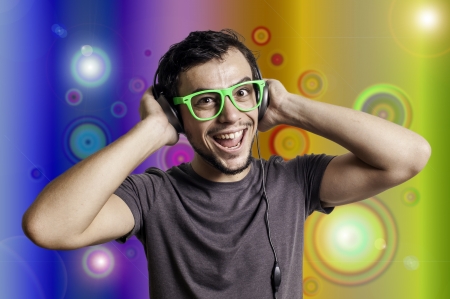 Crazy guy with headphones and green glasses on colorful backgroundの写真素材