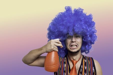 Crazy guy with blue wig on colorful backgroundの写真素材