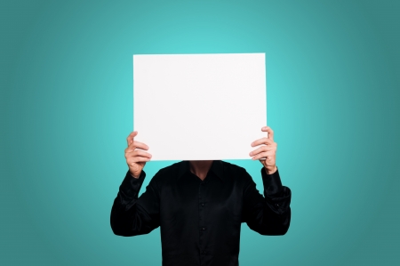 man with black shirt holding blank white board on blue backgroundの写真素材