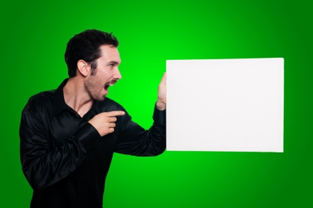 man with mustache and black jacket holding blank white board on green backgroundの写真素材