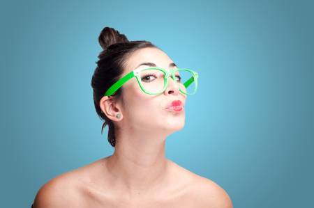 beautiful kissing girl with green eyeglasses on gray backgroundの写真素材
