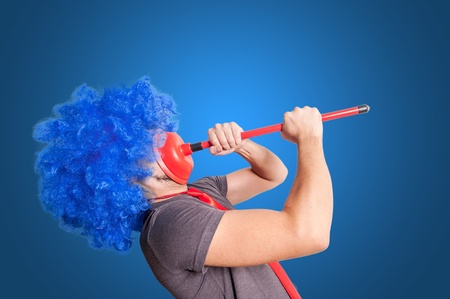 funny guy holding red plunger in his face with blue background
