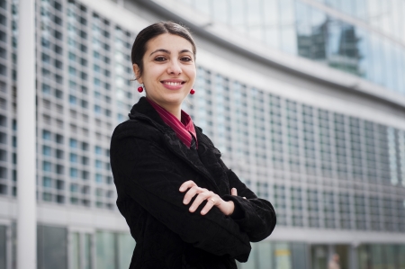 smiling business girl in front of a modern buildingの写真素材