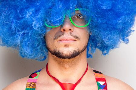 Funny guy naked with blue wig and red tie on green backgrundの写真素材