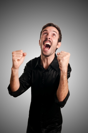 successful business man screaming on blue backgroundの写真素材
