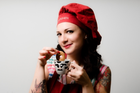 beautiful tattooed pinup cook girl with biscuit on gray backgroundの写真素材