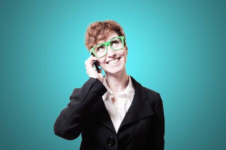 smiling business woman with phone on blue backgroundの写真素材