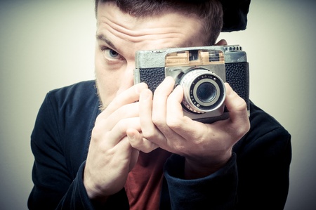 vintage portrait of fashion guy with old camera on gray backgroundの写真素材