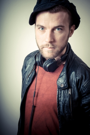 vintage portrait of fashion guy with headphones on gray backgroundの写真素材
