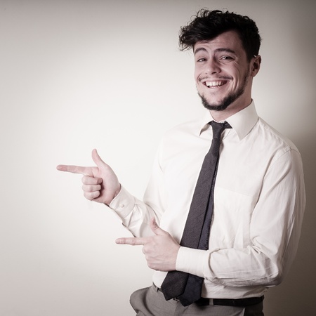 stylish modern guy with white shirt pointing on gray backgroundの写真素材
