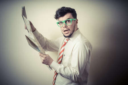 lost businessman with map on gray backgroundの写真素材