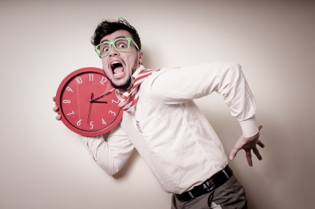 funny businessman with wall clock on gray backgroundの写真素材