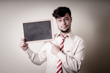 businessman with a blank blackboard on gray backgroundの写真素材