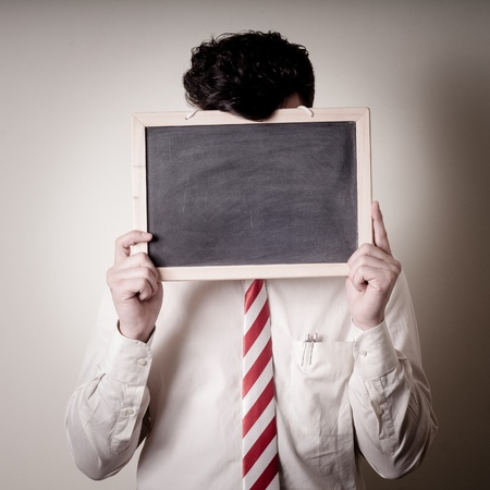 businessman with a blank blackboard on face on gray backgroundの写真素材