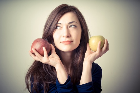 beautiful woman with red and yellow apples on gray backgroundの写真素材