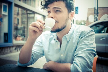 stylish man drinking a coffee at the bar in the cityの写真素材