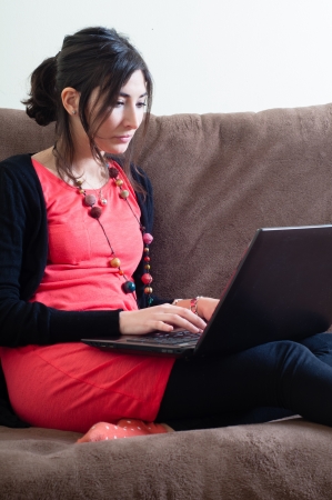 woman at home using notebook on couchの写真素材