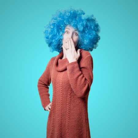 beautiful girl with curly blue wig and turtleneck on colorful backgroundの写真素材