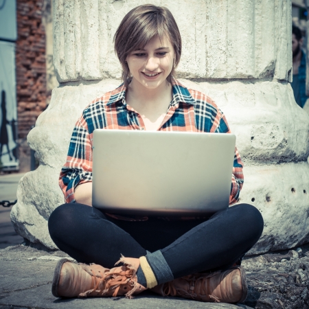 young woman using notebook in the streetの写真素材