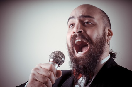  funny elegant singer bearded on vignetting background
