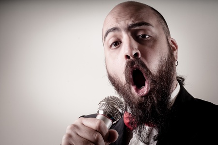  funny elegant singer bearded on vignetting background