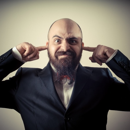  funny elegant bearded man fingers in the ears on vignetting background