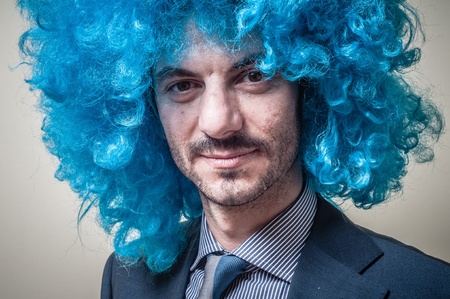 funny businessman with blue wig on  gray backgroundの写真素材