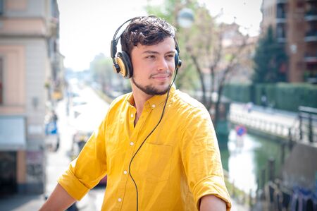 hipster young man listening to music on the balcony の写真素材