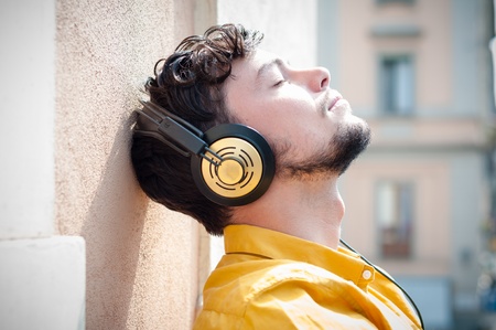 hipster young man listening to music on the balcony の写真素材