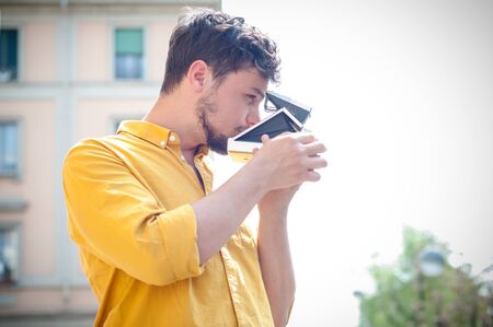 hipster young man with old camera on the balconyの写真素材
