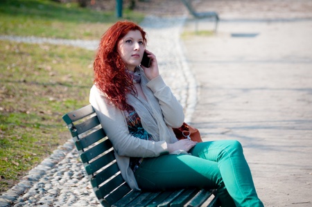 beautiful young woman on the phone in the parkの写真素材