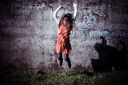 happy eastern vintage hipster woman jumping in the parkの写真素材