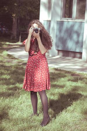 hipster vintage woman with old camera in the parkの写真素材