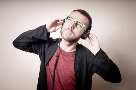 stylish hipster listening to music on gray backgroundの写真素材