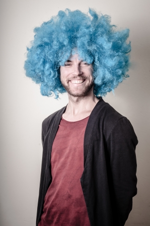 hipster stylish funny man with blue wig on gray backgroundの写真素材