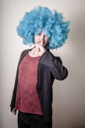 hipster stylish funny man with blue wig on gray backgroundの写真素材