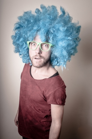 hipster stylish funny man with blue wig on gray backgroundの写真素材