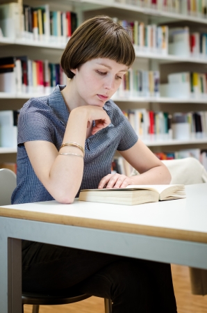 young beautiful hipster woman in libraryの写真素材