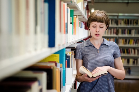 young beautiful hipster woman in libraryの写真素材