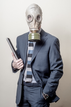 businessman with gas mask with notebook on gray backgroundの写真素材