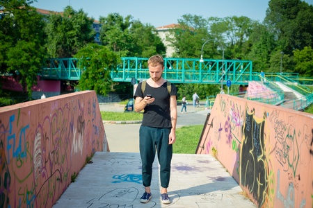 hipster modern stylish blonde man with phone in daily life