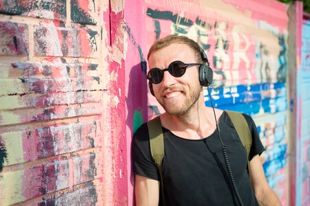 hipster modern stylish blonde man listening music in daily life