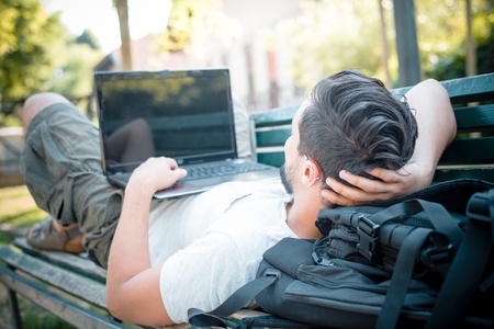 young stylish man using notebook at the parkの写真素材