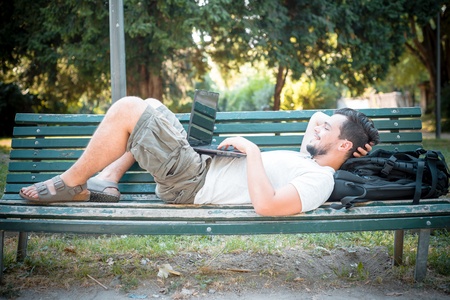 young stylish man using notebook at the parkの写真素材