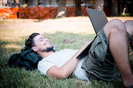 young stylish man using notebook at the parkの写真素材